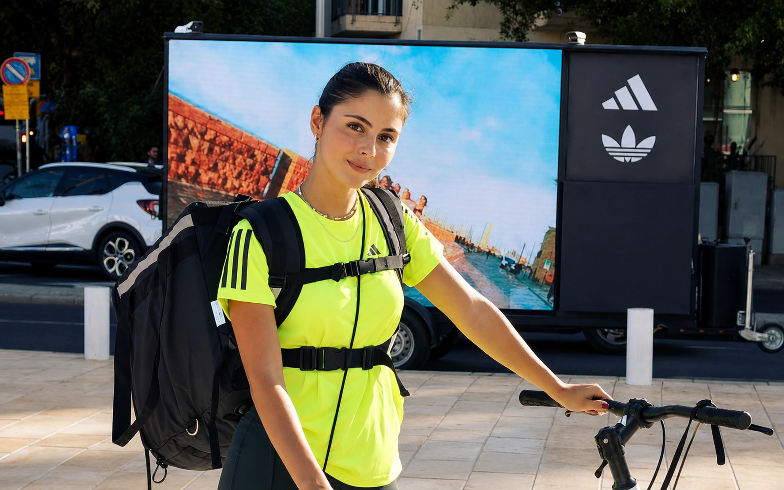 דיילת ADIDAS לצד מסך LED נייד המציג תוכן ממותג ברחוב